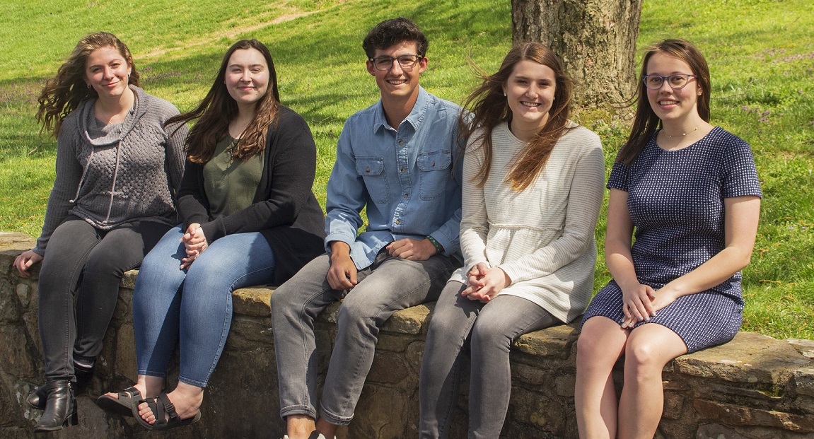 Students setting on curb 